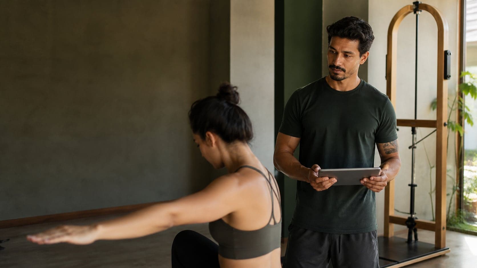 A coach follows a client's movement in a calm studio